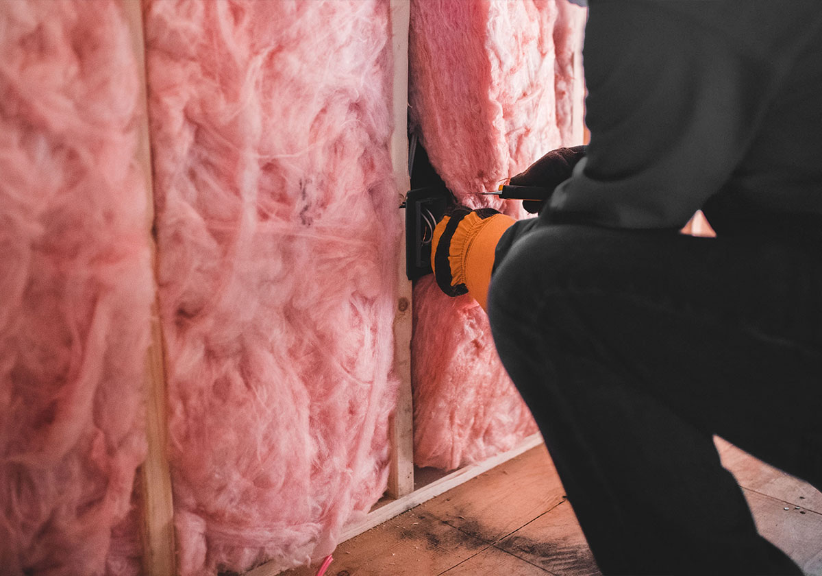 Professionnel-posant-un-isolant-dans-une-paroi-intérieure-en-cours-de-construction